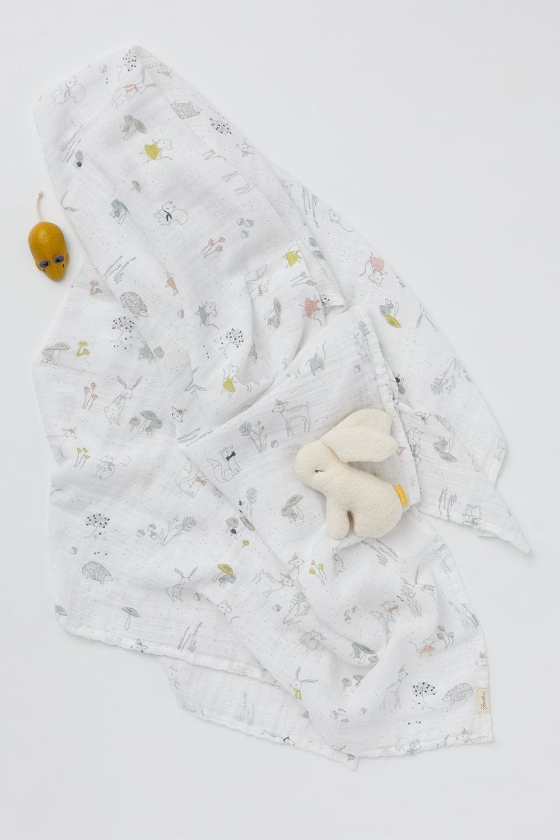 Pehr Magical Forest Organic Novelty Swaddles with mouse and bunny toy. Organic cotton, hand printed. White with forest animal and plant pattern.
