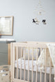 Pehr Little Lamb Classic Mobile over baby crib. Baby in crib looking at Pehr Little Lamb Classic Mobile. Ethically Handmade using 100% wool and AZO-Free dyes. Mobile with Lambs.